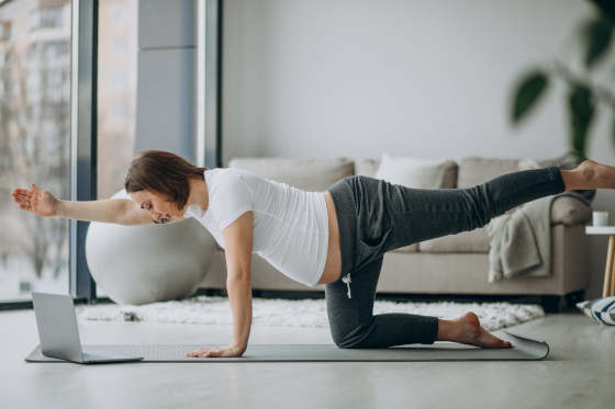 Pregnant woman exercing yoga at home